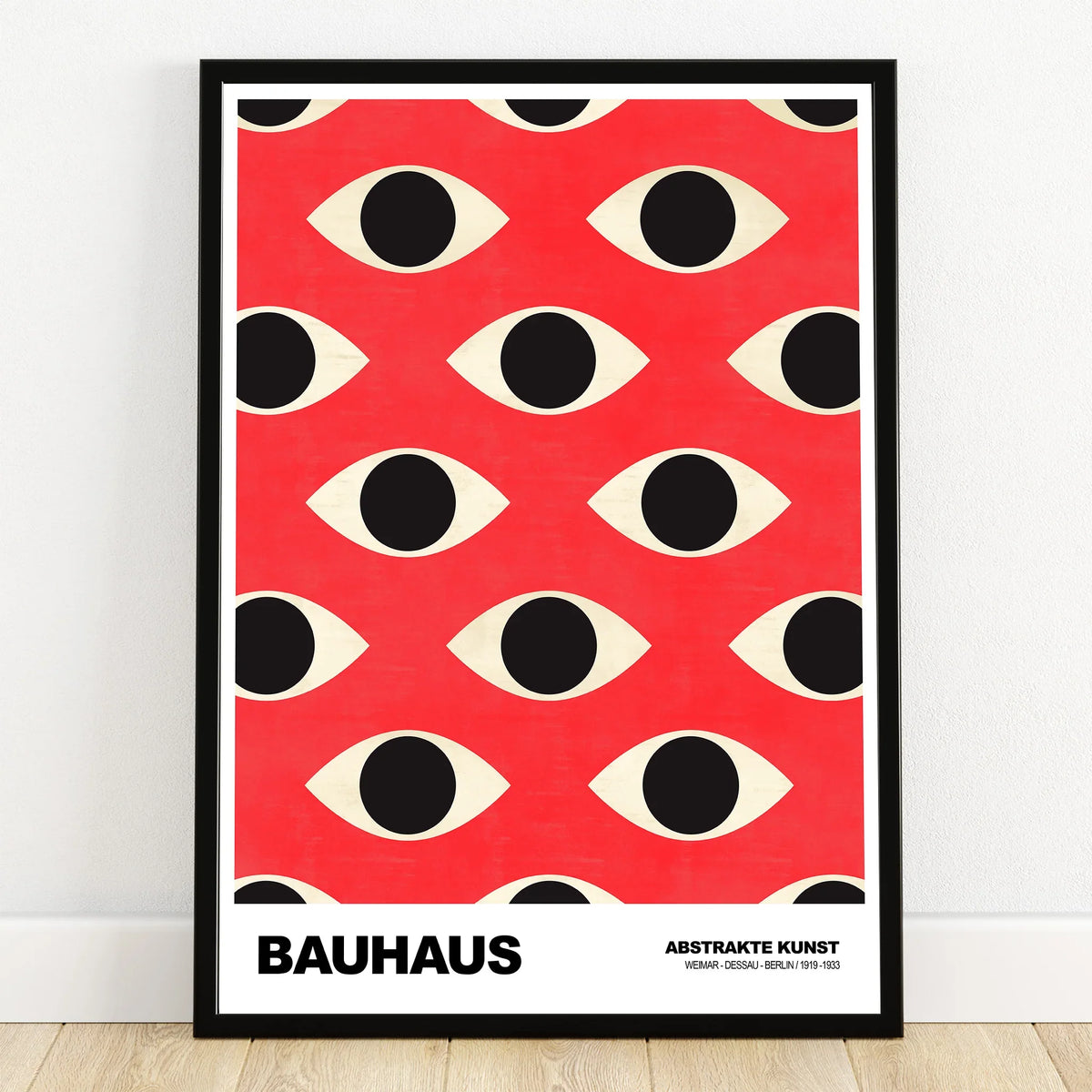 Bauhaus style abstract art print with black eye pattern on red background in black frame.