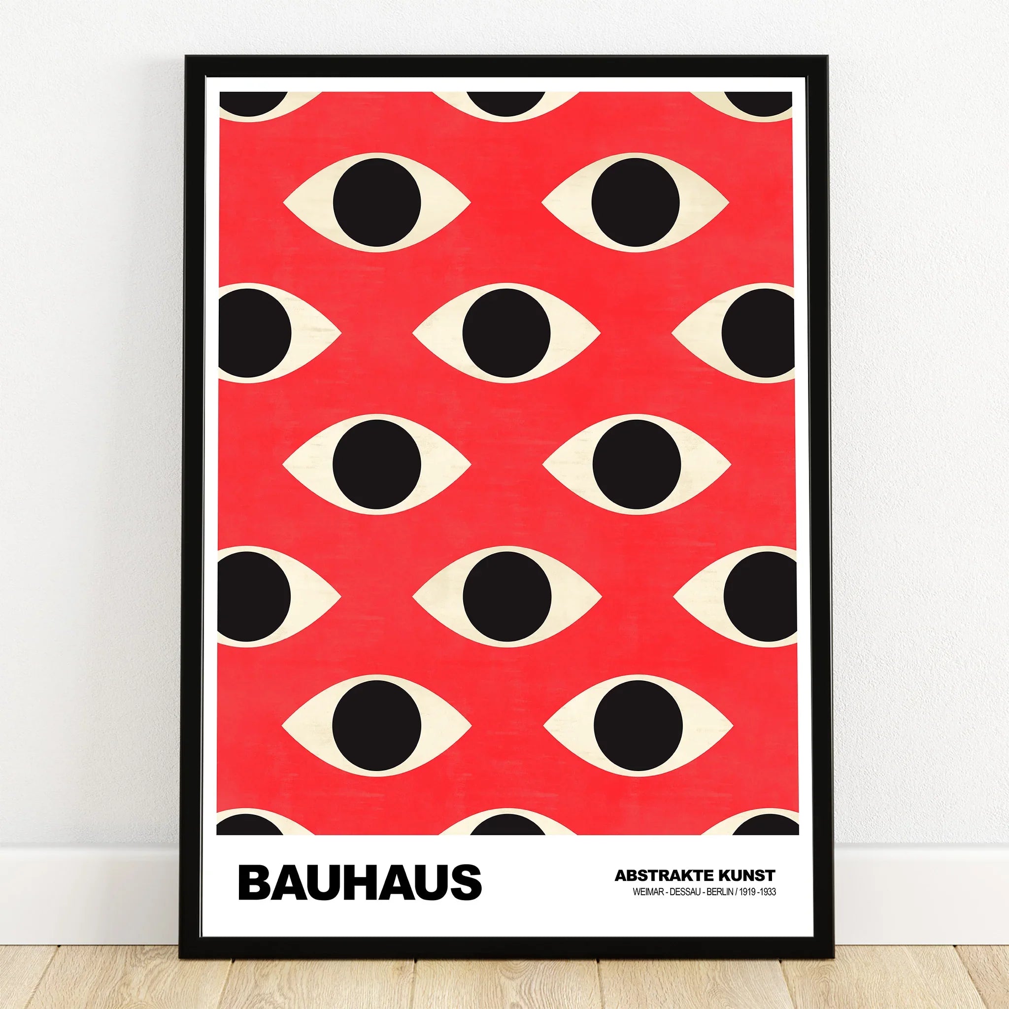 Bauhaus style abstract art print with black eye pattern on red background in black frame.