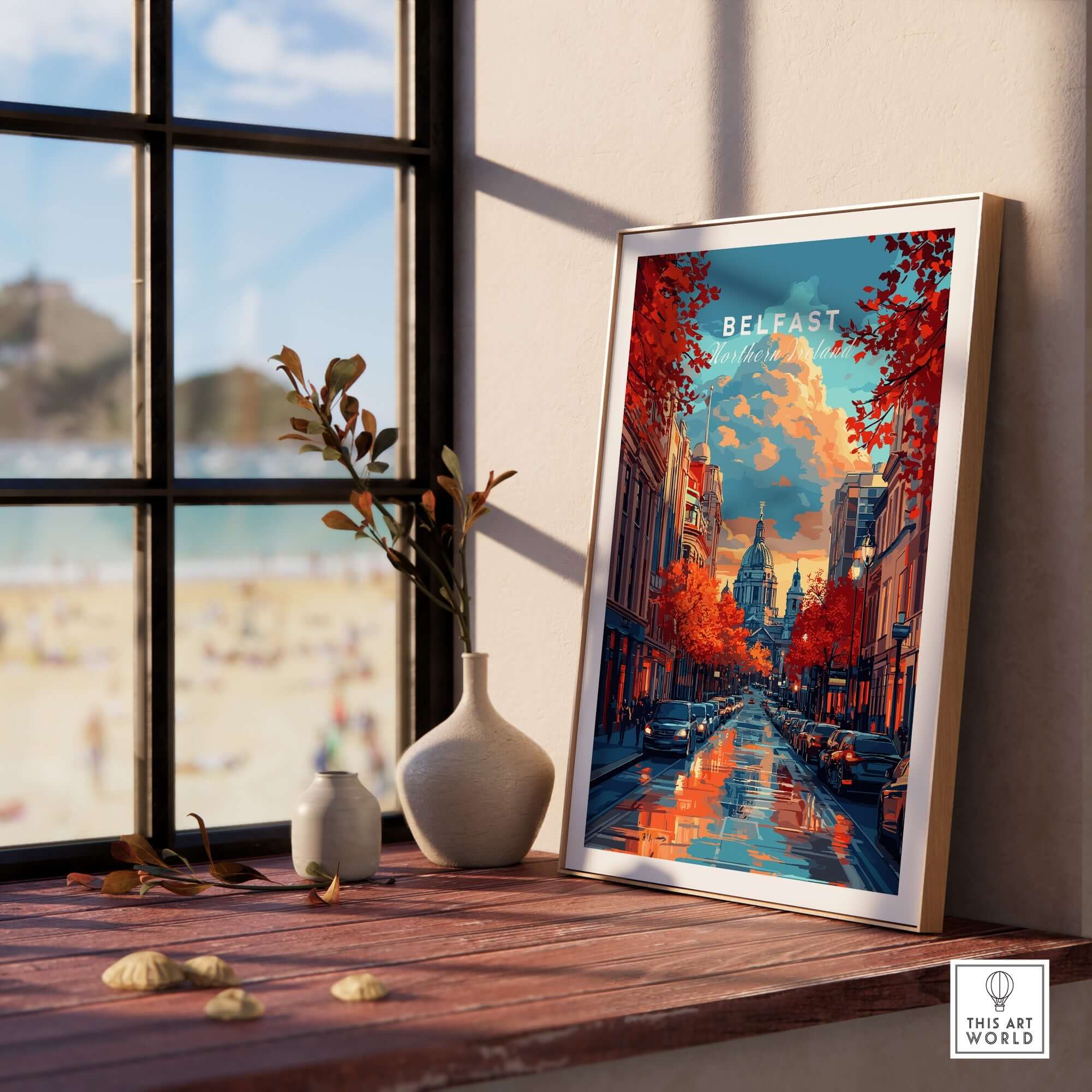 Belfast Travel Print displayed in a sunny room with a view of the beach, showcasing vibrant colors and city landscapes.