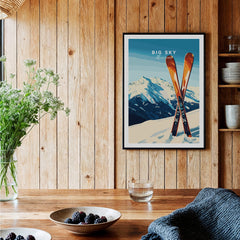 Big Sky Print Montana - Ski Poster framed on a wooden wall with skis and decorative plants.