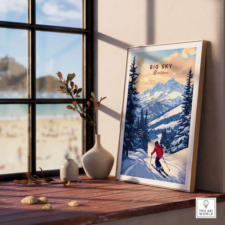 Big Sky Montana ski print poster displayed on a wooden table near a window, with mountains and a skier in the artwork.