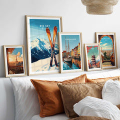 Big Sky Print Montana ski poster displayed with framed city posters on a stylish bed with decorative pillows.