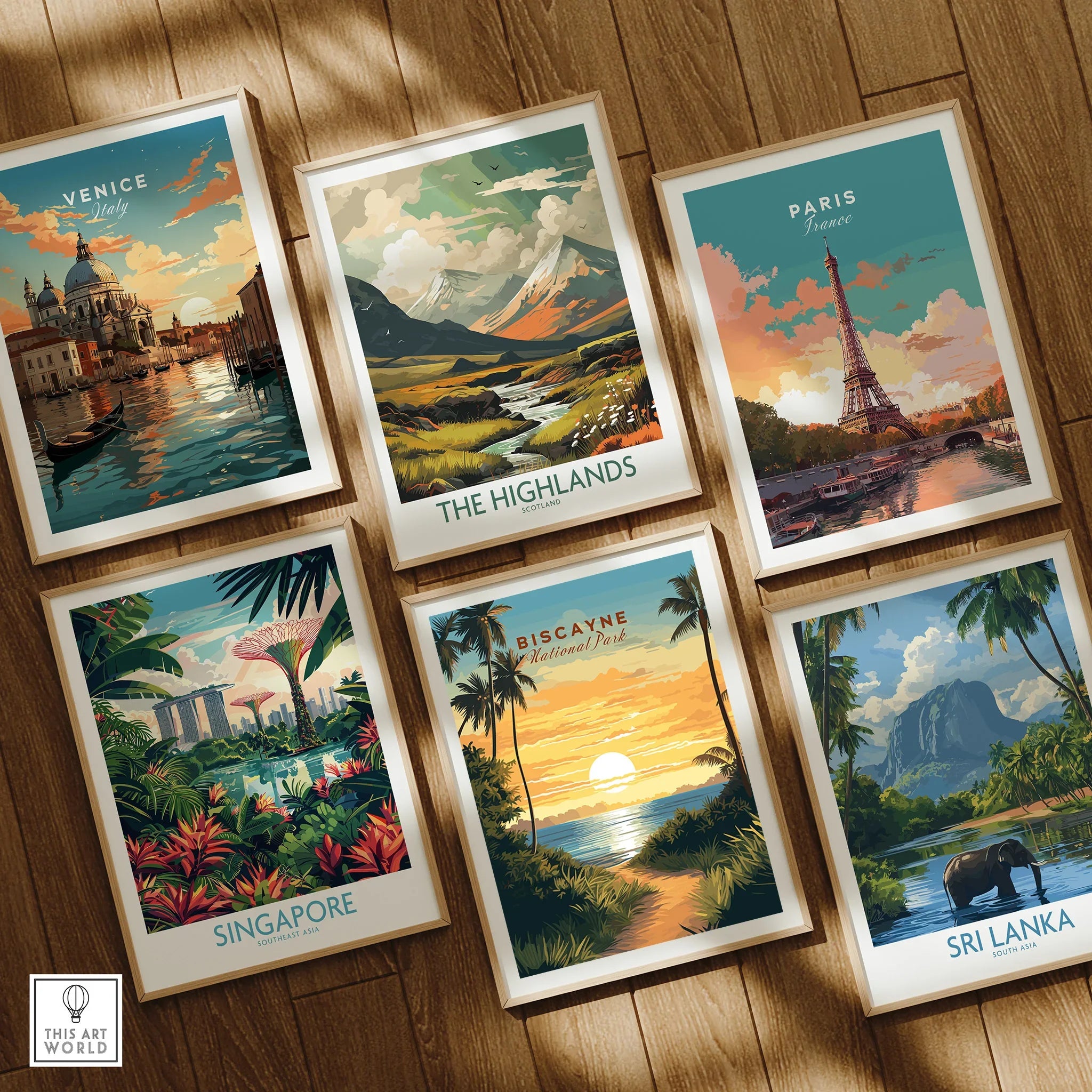 Set of six framed travel art prints on wooden floor, featuring Venice, Paris, Singapore, The Highlands, Biscayne National Park, and Sri Lanka scenes.
