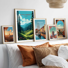 Framed Black Forest Poster Print showcasing scenic views of Germany and other travel destinations, displayed on a cozy couch.