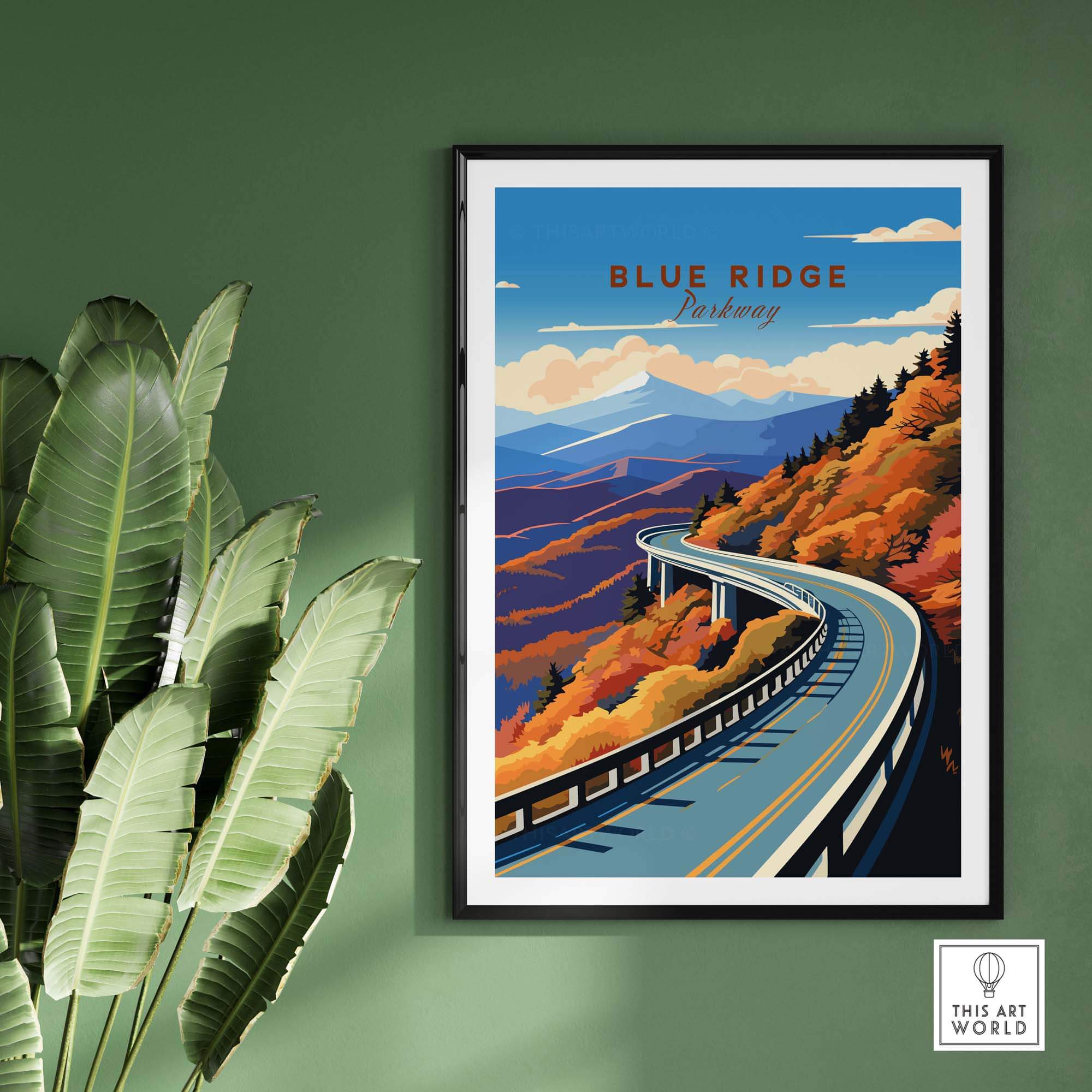 Blue Ridge Parkway poster featuring vibrant autumn colors and winding road, framed on green wall with plant.