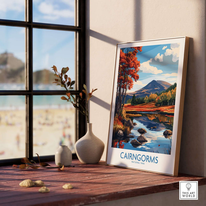 Cairngorms National Park wall art print displayed on a wooden table beside a vase, with a scenic landscape in the background.