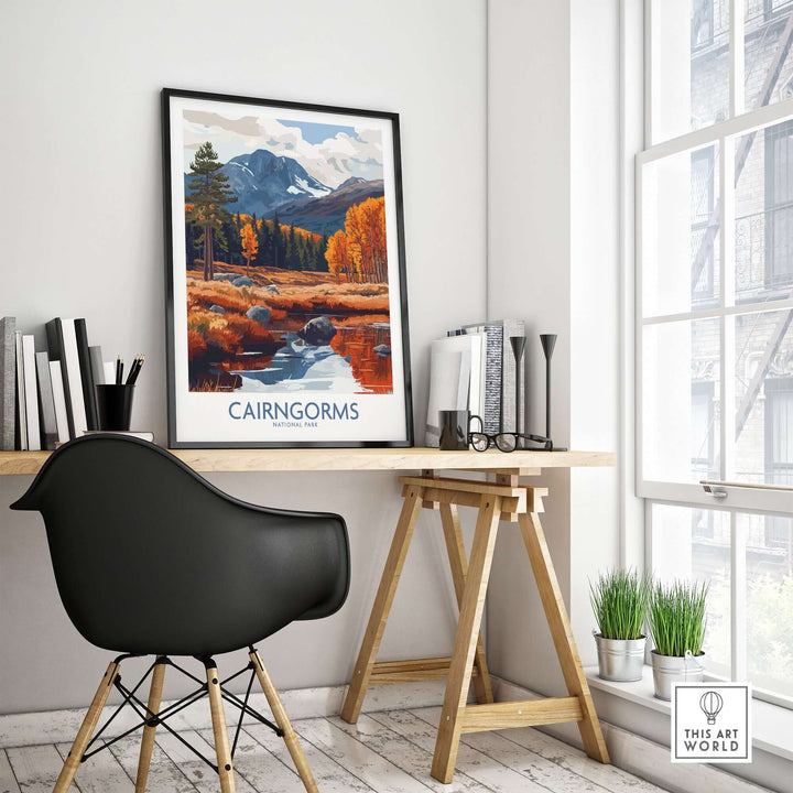 Cairngorms travel poster displayed in a stylish workspace, featuring mountains and autumn scenery.