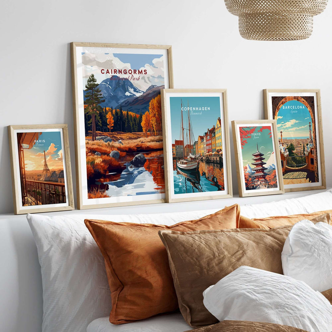 Cairngorms travel print showcased among framed artworks of various cities on a cozy sofa with decorative pillows.