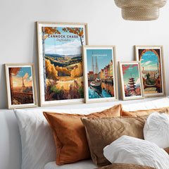 Cannock Chase Travel Print displayed among travel posters on a stylish sofa with decorative cushions.