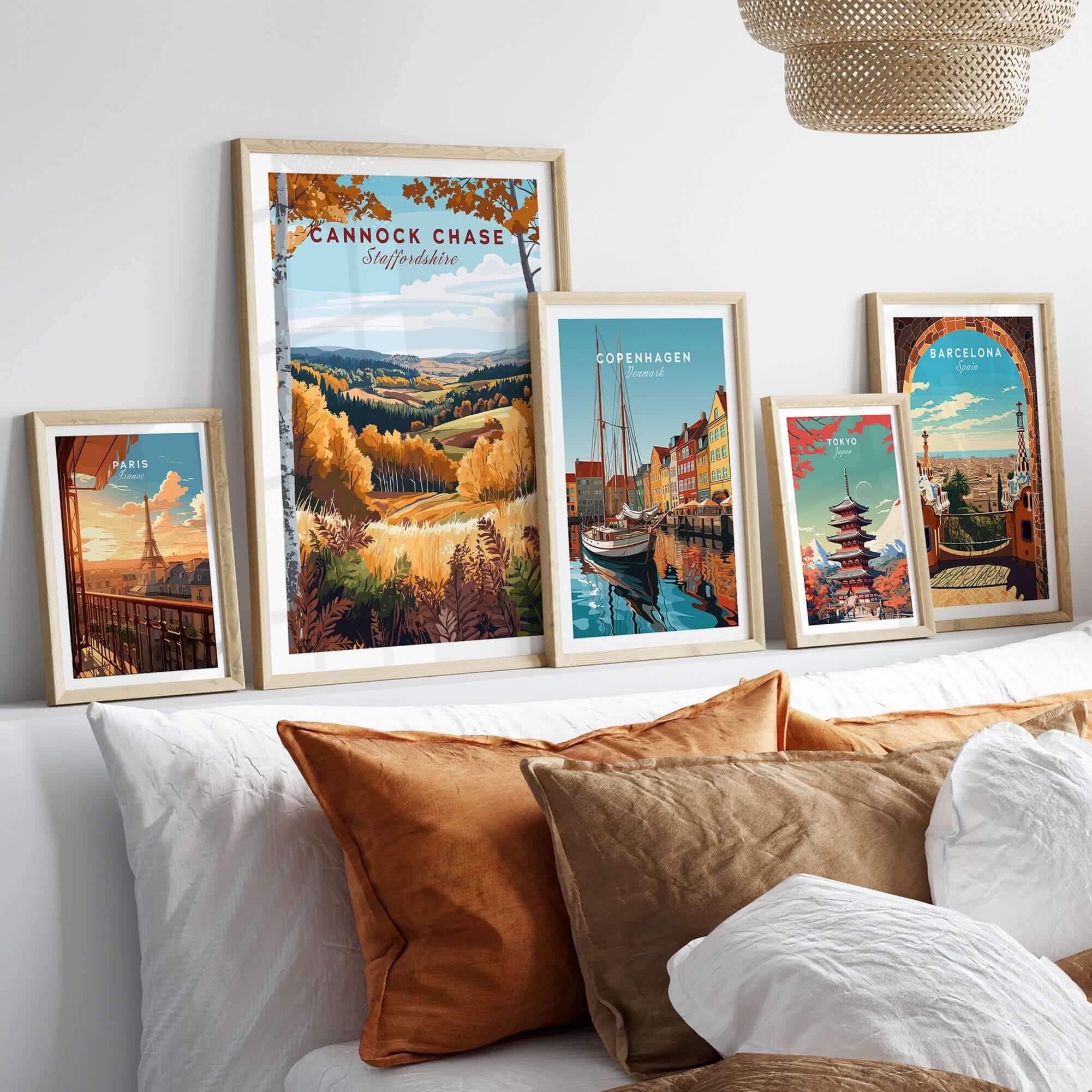 Cannock Chase Travel Print displayed among travel posters on a stylish sofa with decorative cushions.
