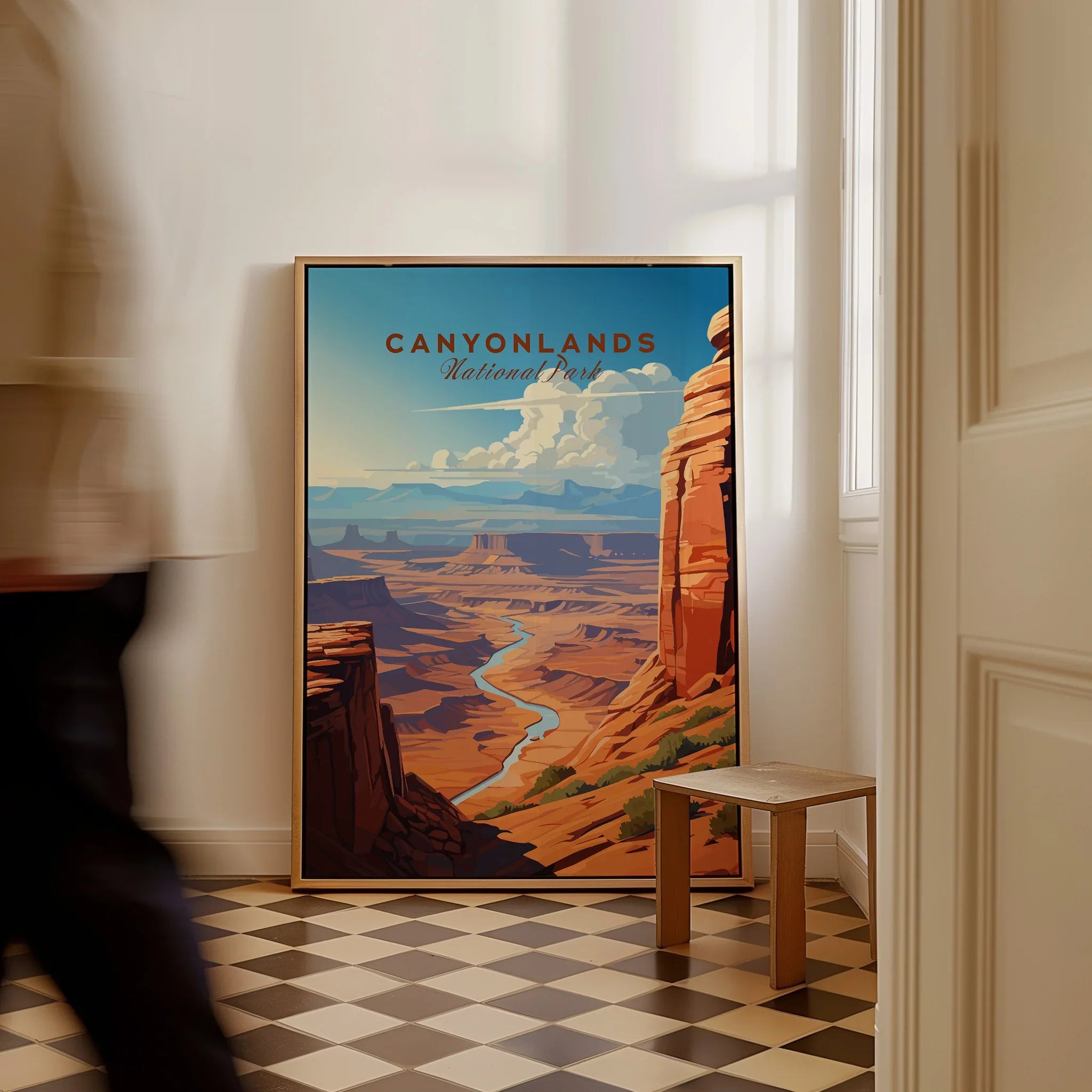 Framed Canyonlands National Park travel poster on floor, person walking past in modern home.