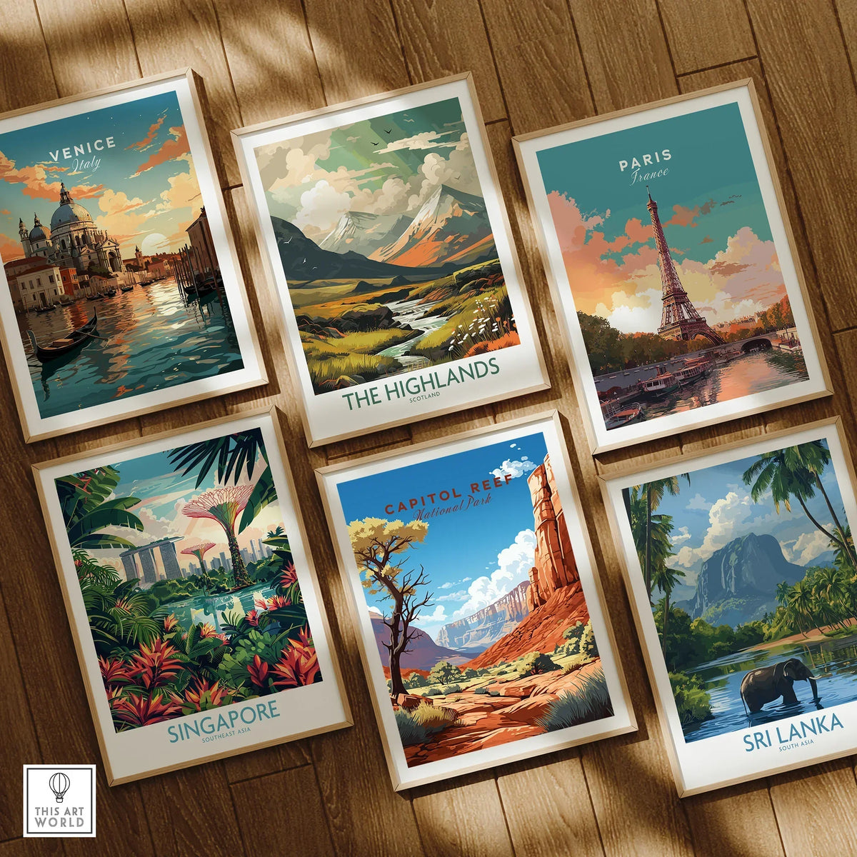 Set of six framed travel posters featuring Venice, Paris, Singapore, Sri Lanka, Scotland Highlands, and Capitol Reef National Park on a wooden floor.