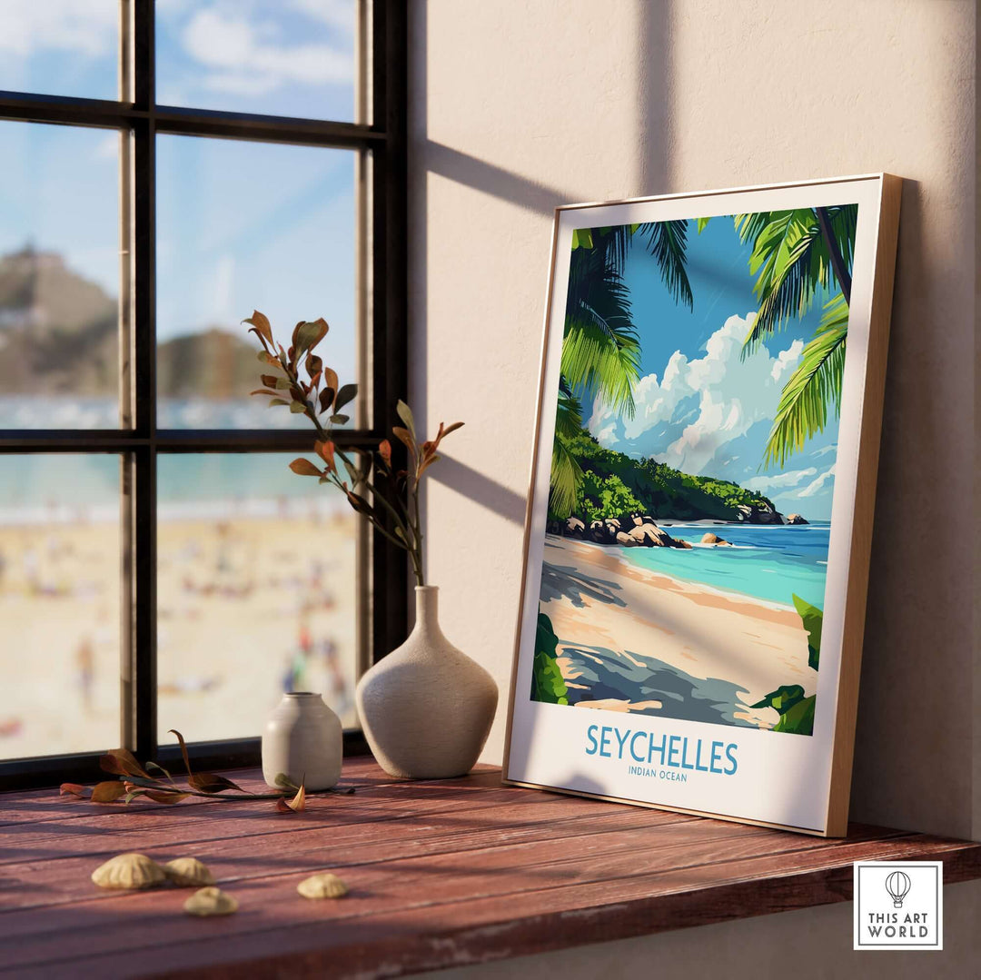 Framed Seychelles beach print on a windowsill with a view of the ocean and sandy beach, perfect for tropical decor.