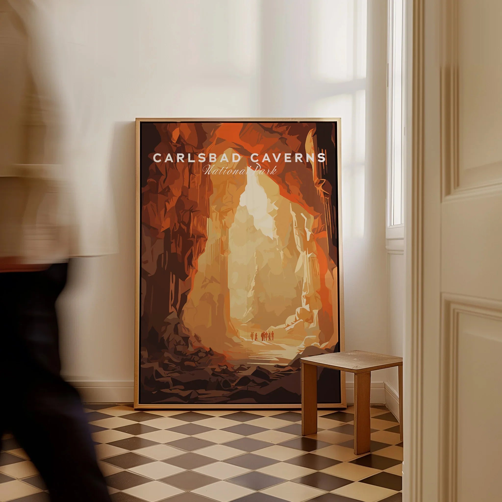 Framed Carlsbad Caverns National Park travel poster on floor, man walking by, checkered tiles