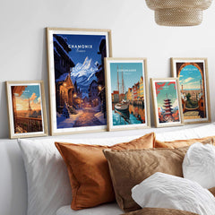 Chamonix poster displayed among framed city posters on a cozy bed, adding charm to home decor.