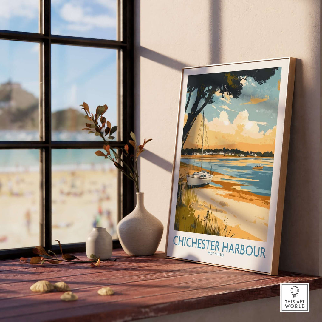 Chichester Harbour travel poster displayed by a window, showcasing coastal beauty and vibrant colors in a stylish home setting.