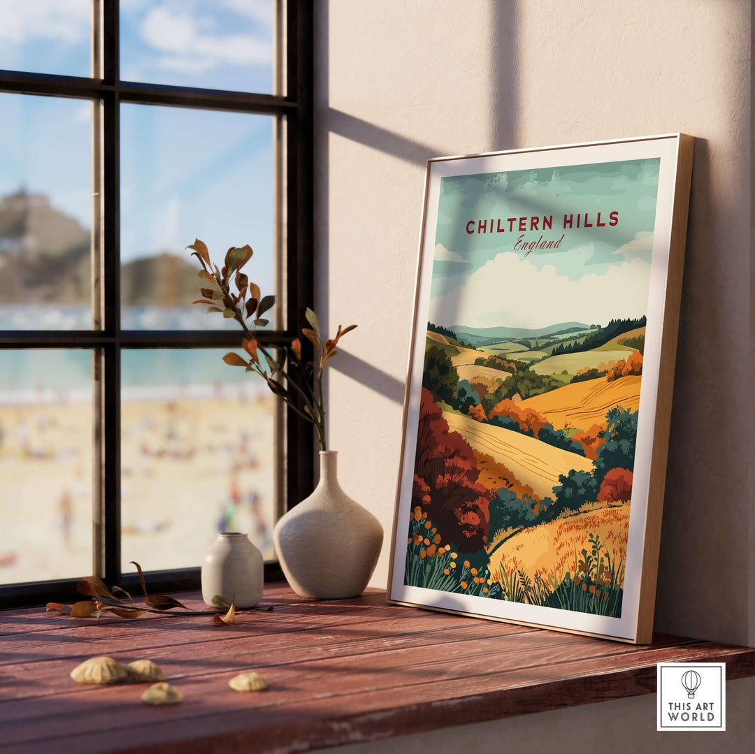 Chiltern Hills travel print displayed on a windowsill, showcasing a vibrant landscape of rolling hills and autumn colors.