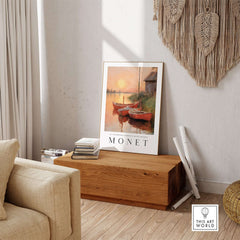 Claude Monet Art Print - Red Boats at Sunset Riverbank Wall Art displayed in a cozy interior setting.
