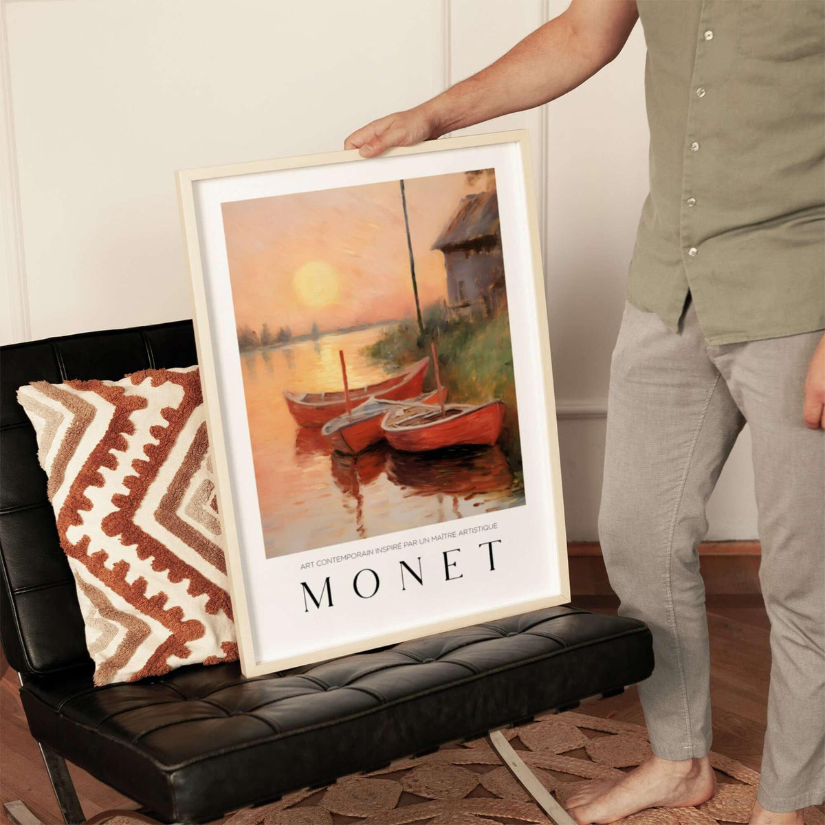 Claude Monet Art Print - Red Boats at Sunset Riverbank Wall Art displayed on a chair with person holding the frame.
