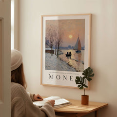Claude Monet Poster - Winter River Sunset Wall Art - Snow Scene Print displayed in a cozy interior with a person reading.
