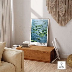 Claude Monet Print - Calm Lily Pads on Blue Water Wall Art displayed in a cozy living room setting.