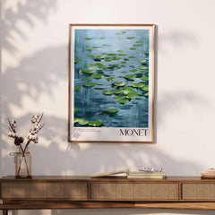 Claude Monet Print - Calm Lily Pads on Blue Water Wall Art in a modern frame on a stylish wooden console table.