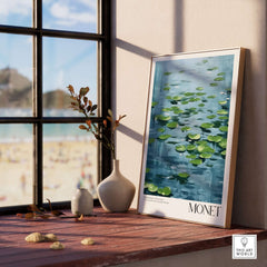 Claude Monet Print - Calm Lily Pads on Blue Water Wall Art displayed in a sunlit room near a window.