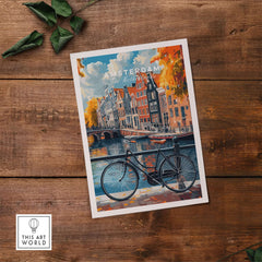 Colorful Amsterdam Canal House Poster - Classic Dutch Canal Scene Print on a wooden table with a bicycle.