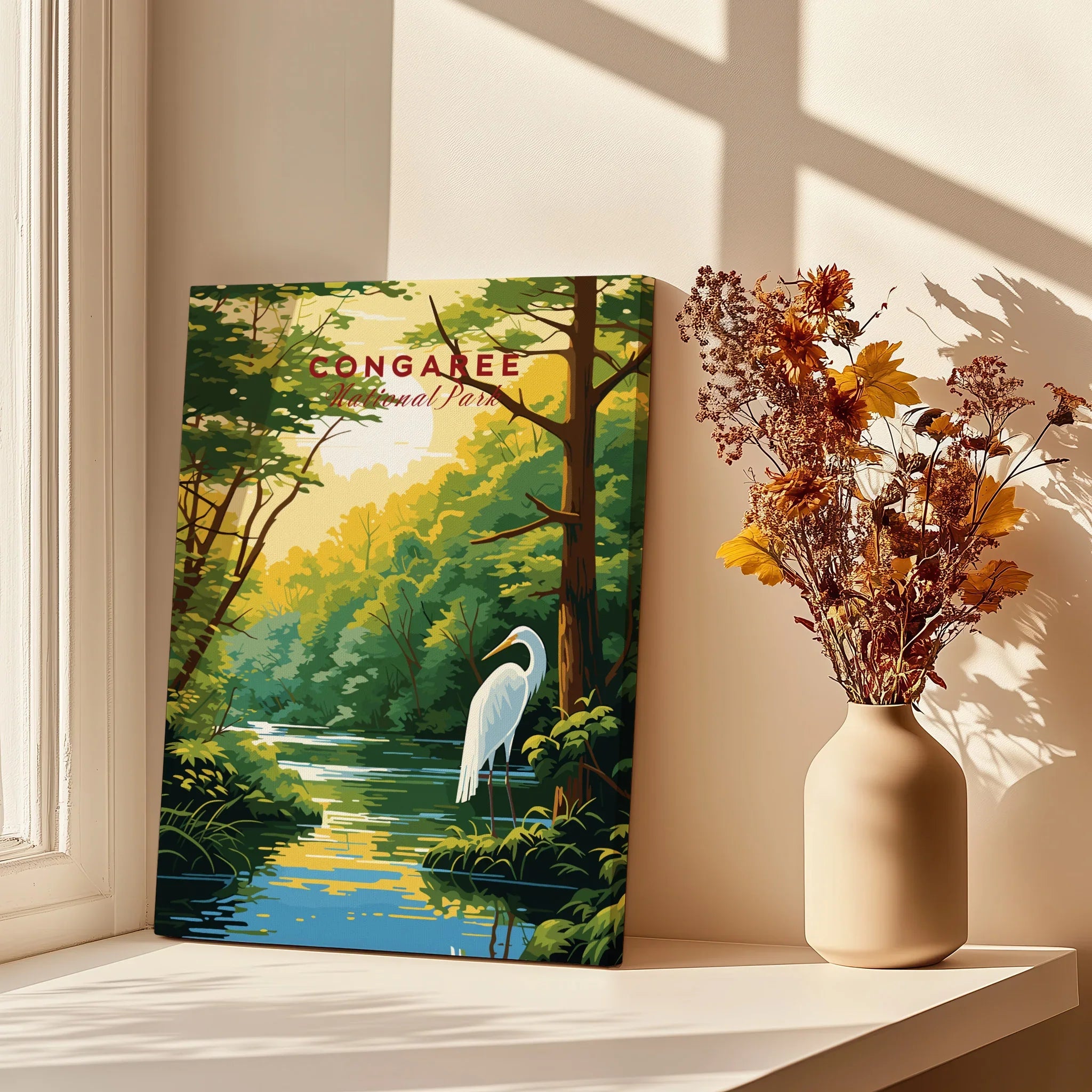 Congaree National Park wall art print with heron by a river, displayed on sunlit windowsill next to vase of dried flowers