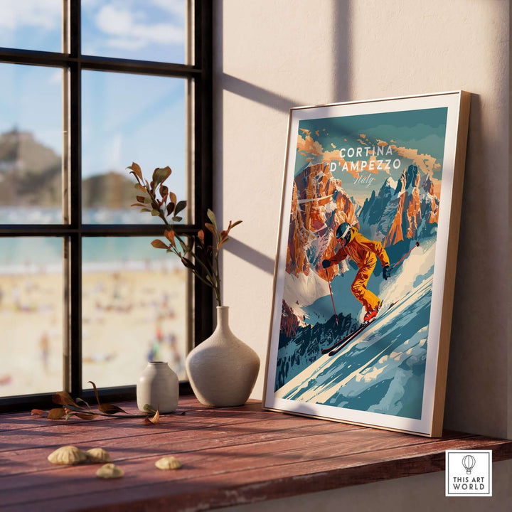 Cortina d'Ampezzo ski poster displayed on a wooden table by a sunny window, showcasing a skier in action against a mountain backdrop.