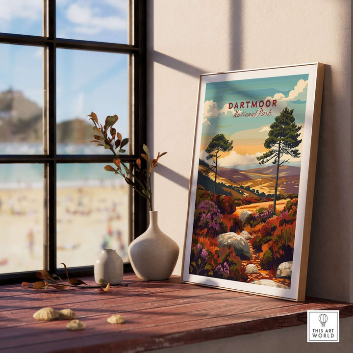 Dartmoor National Park wall art displayed on a wooden table near a window, showcasing vibrant landscapes and greenery.