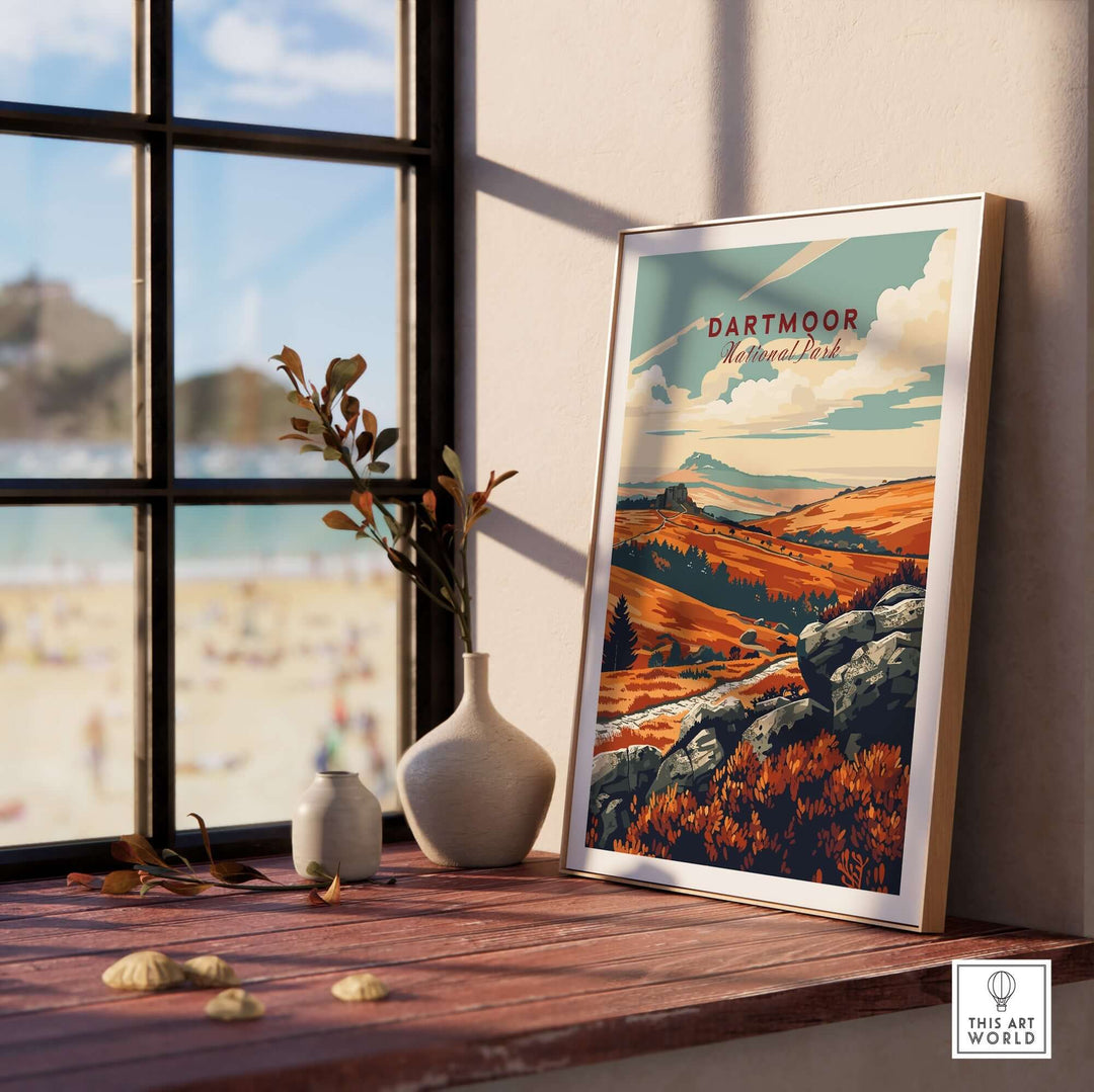 Dartmoor National Park poster displayed on a wooden shelf beside a vase and window, showcasing stunning landscape art.