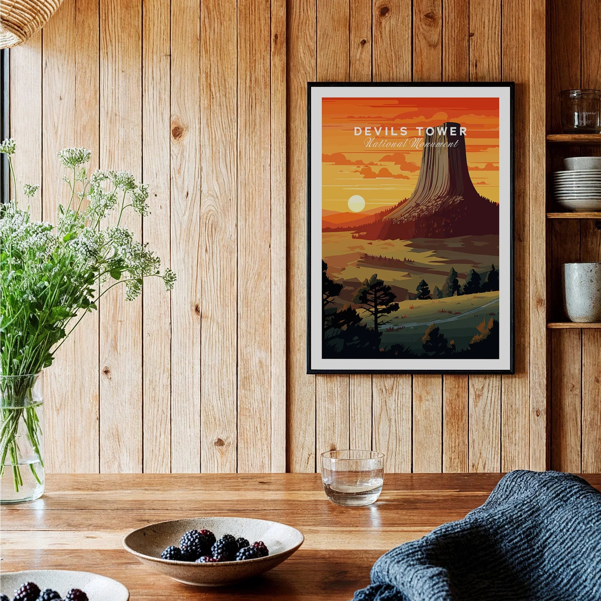 Framed Devils Tower National Monument art print in rustic kitchen with wood wall and flowers