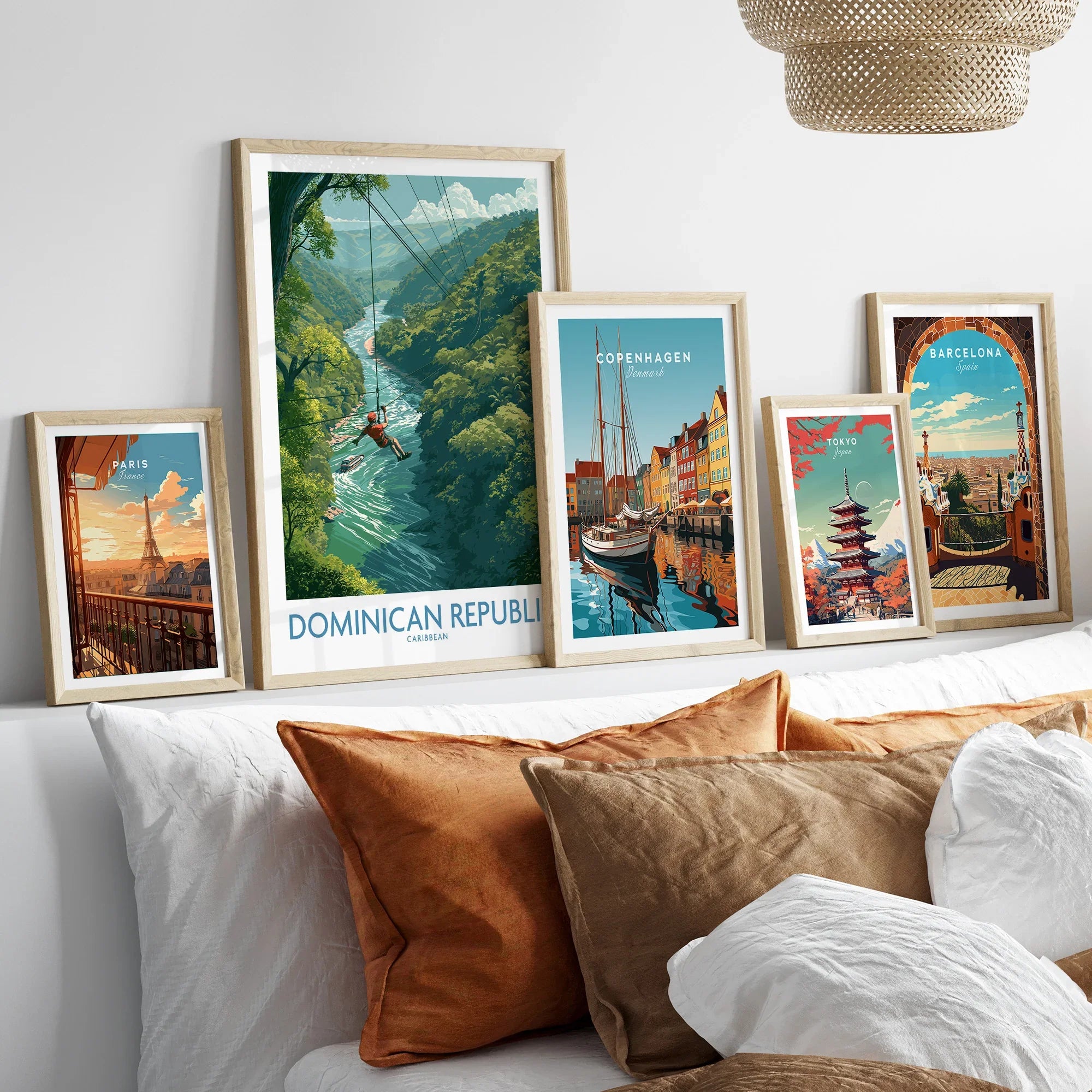 Travel posters of Paris, Dominican Republic, Copenhagen, Tokyo, and Barcelona in wooden frames above a bed
