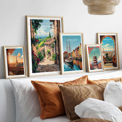 Dordogne Travel Print and other travel-themed art displayed in stylish frames on a cozy sofa.