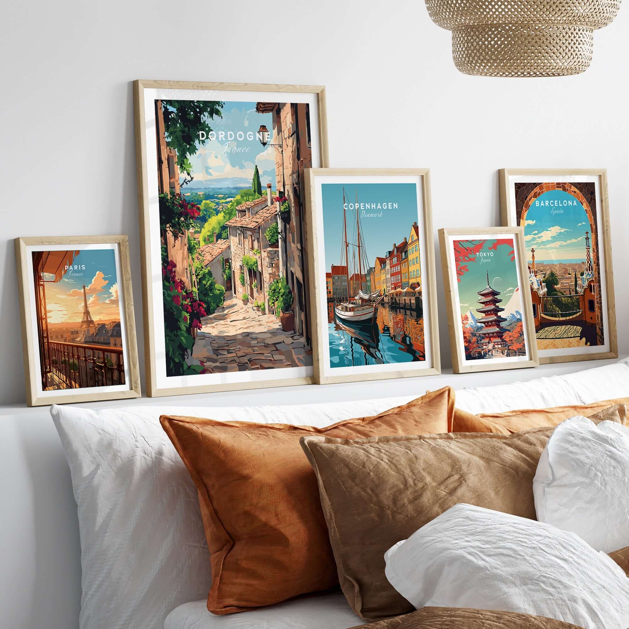 Dordogne Travel Print and other travel-themed art displayed in stylish frames on a cozy sofa.
