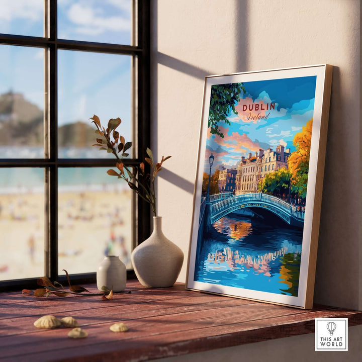 Dublin travel print featuring a colorful scene with a bridge, framed and displayed on a wooden table by a window.