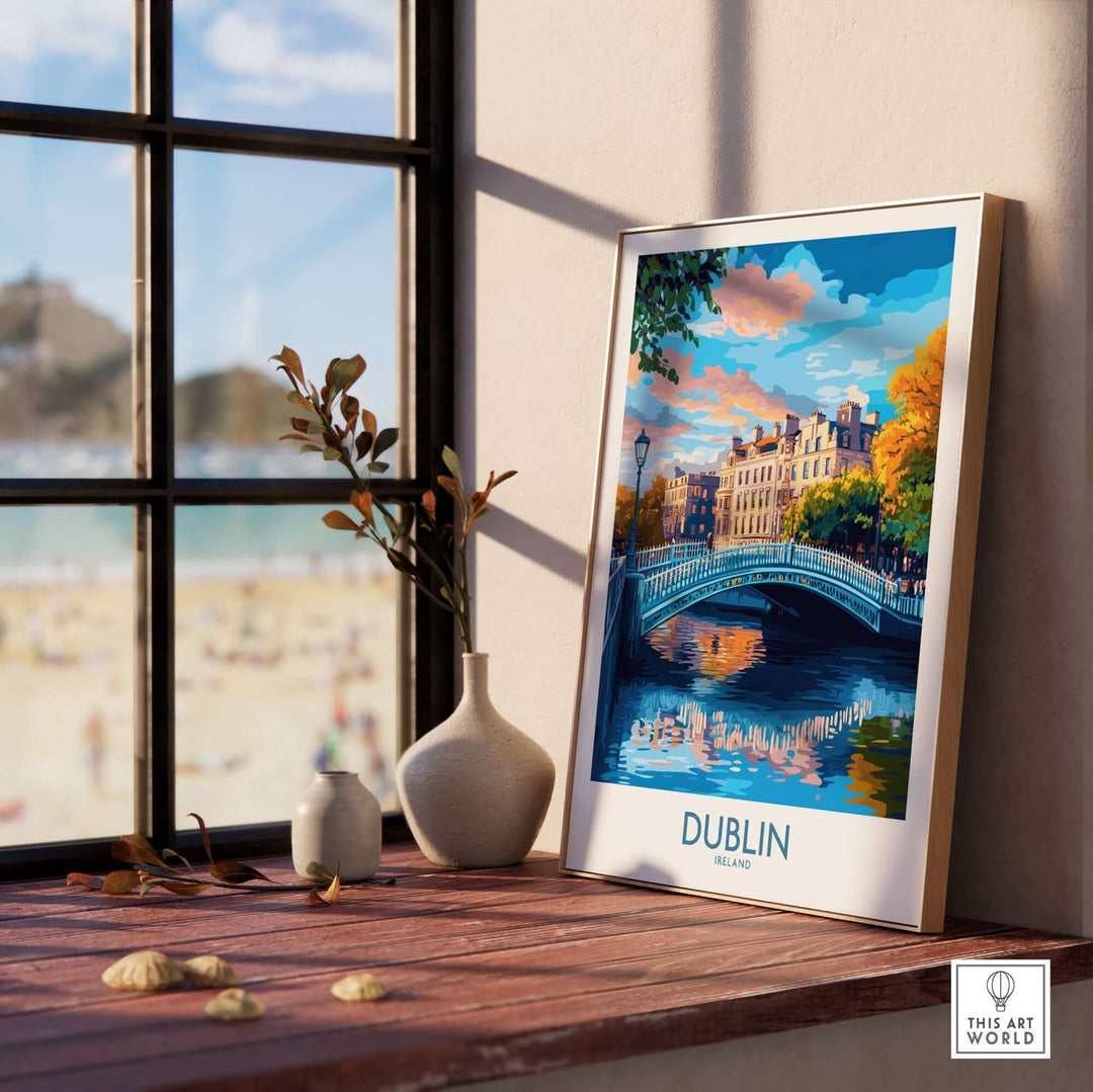 Framed Dublin wall art featuring a scenic view of a bridge and colorful buildings by the river, displayed on a windowsill.