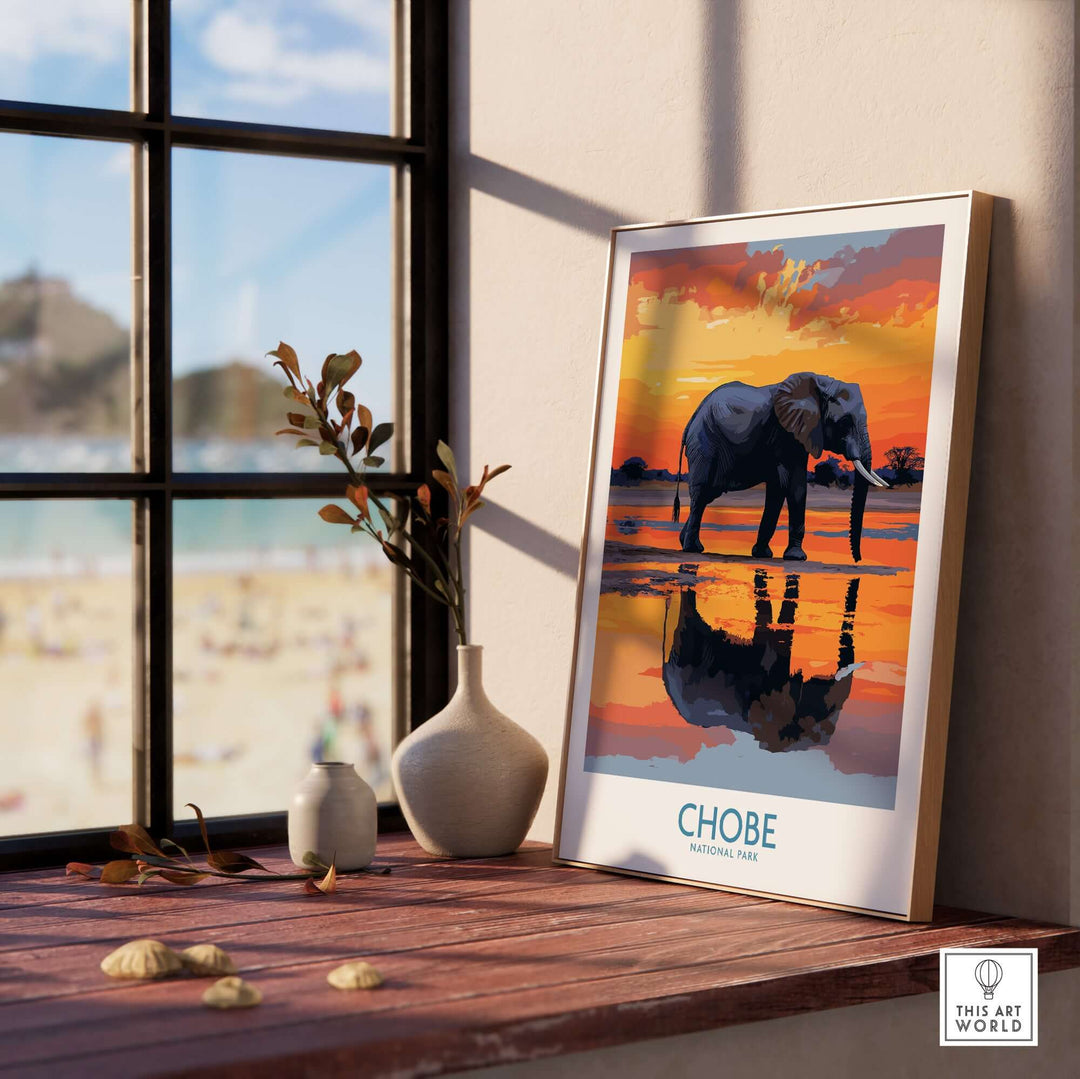 Stylish elephant wall art poster of Chobe National Park, Botswana, displayed on a wooden table by a window.