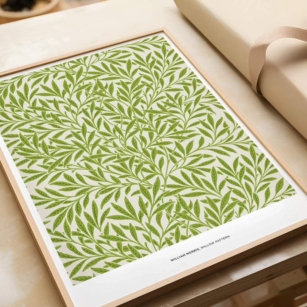 Framed botanical wall art print with green willow leaf pattern, unwrapped on table