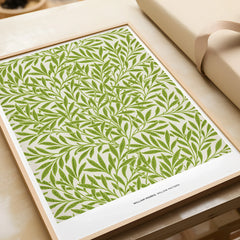 Framed botanical wall art print with green willow leaf pattern, unwrapped on table