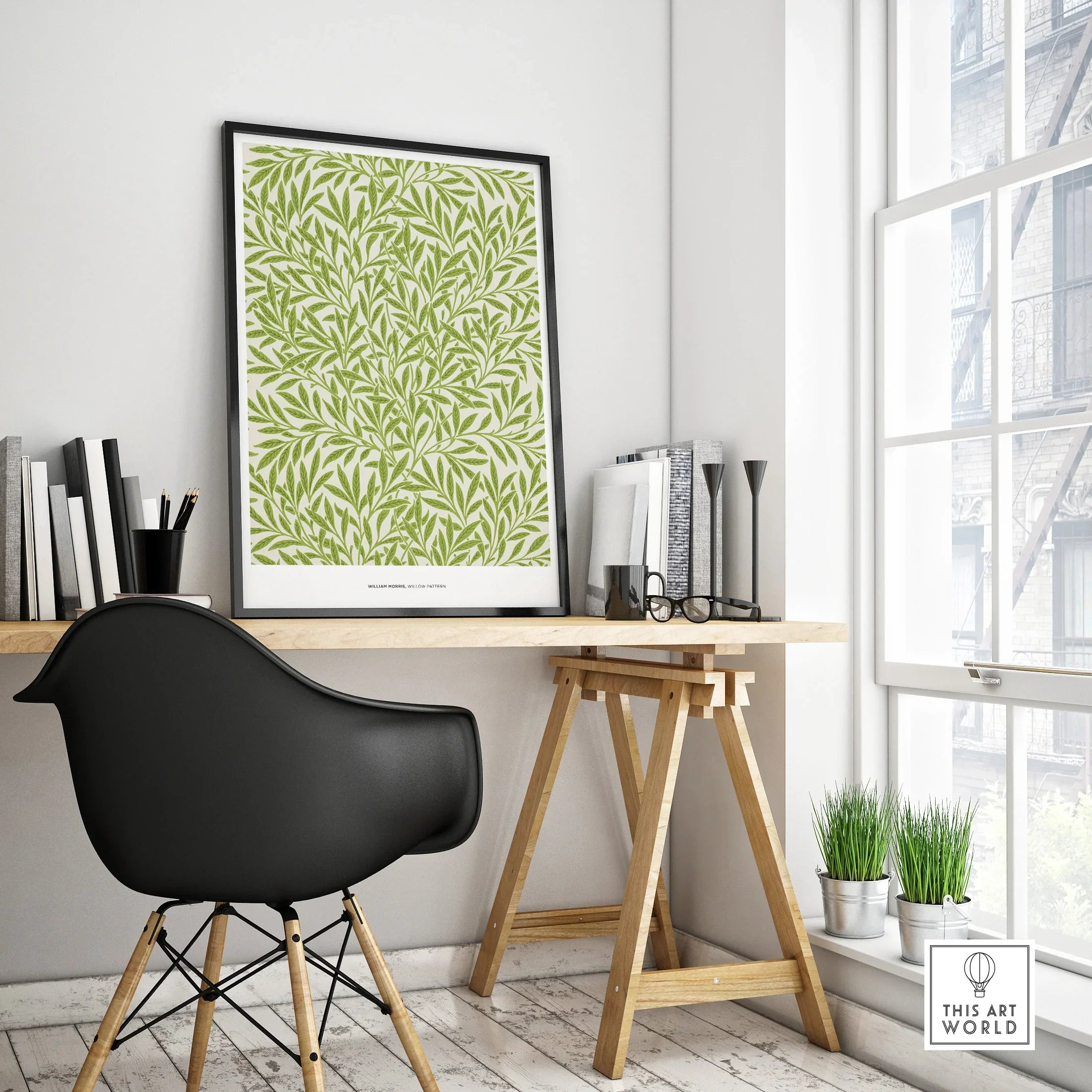 Framed green botanical art print on modern office desk with black chair and natural light