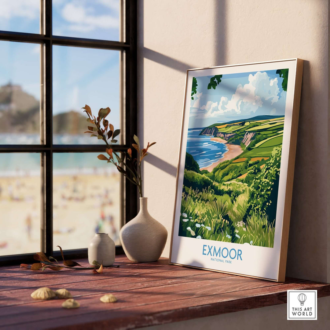 Exmoor National Park travel print displayed on a wooden shelf with a beach view behind, enhancing home decor and nature's beauty.