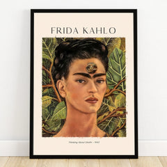 Framed Frida Kahlo portrait wall art with lush leaves, titled 'Thinking About Death 1943'.