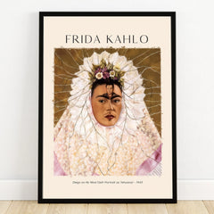 Frida Kahlo art print in black frame, featuring floral headpiece and detailed self-portrait.