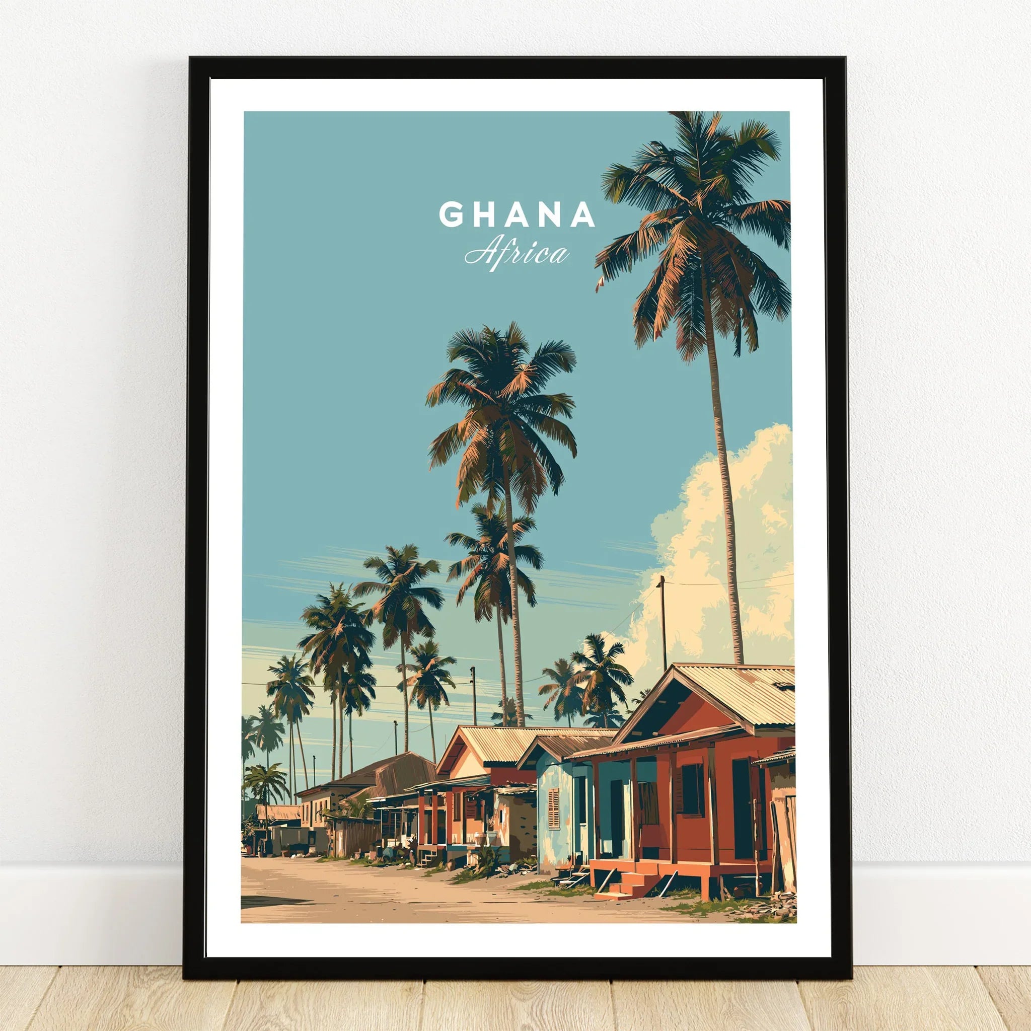 Ghana Coastal Village Travel Poster — art print in black frame on wooden floor