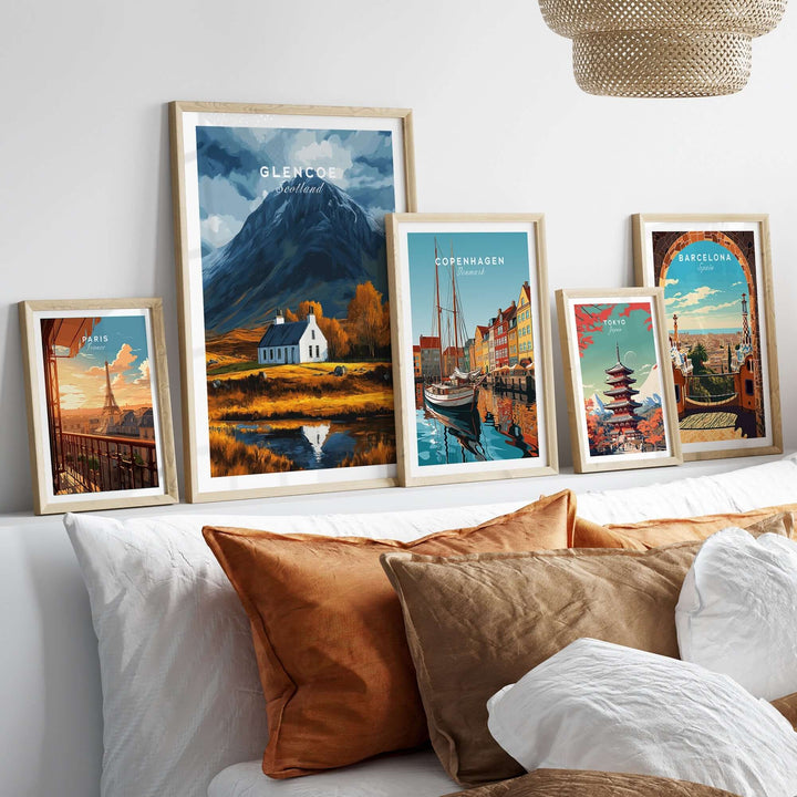 Glencoe Scotland poster displayed among framed travel prints on a cozy couch, showcasing nature and adventure themes.