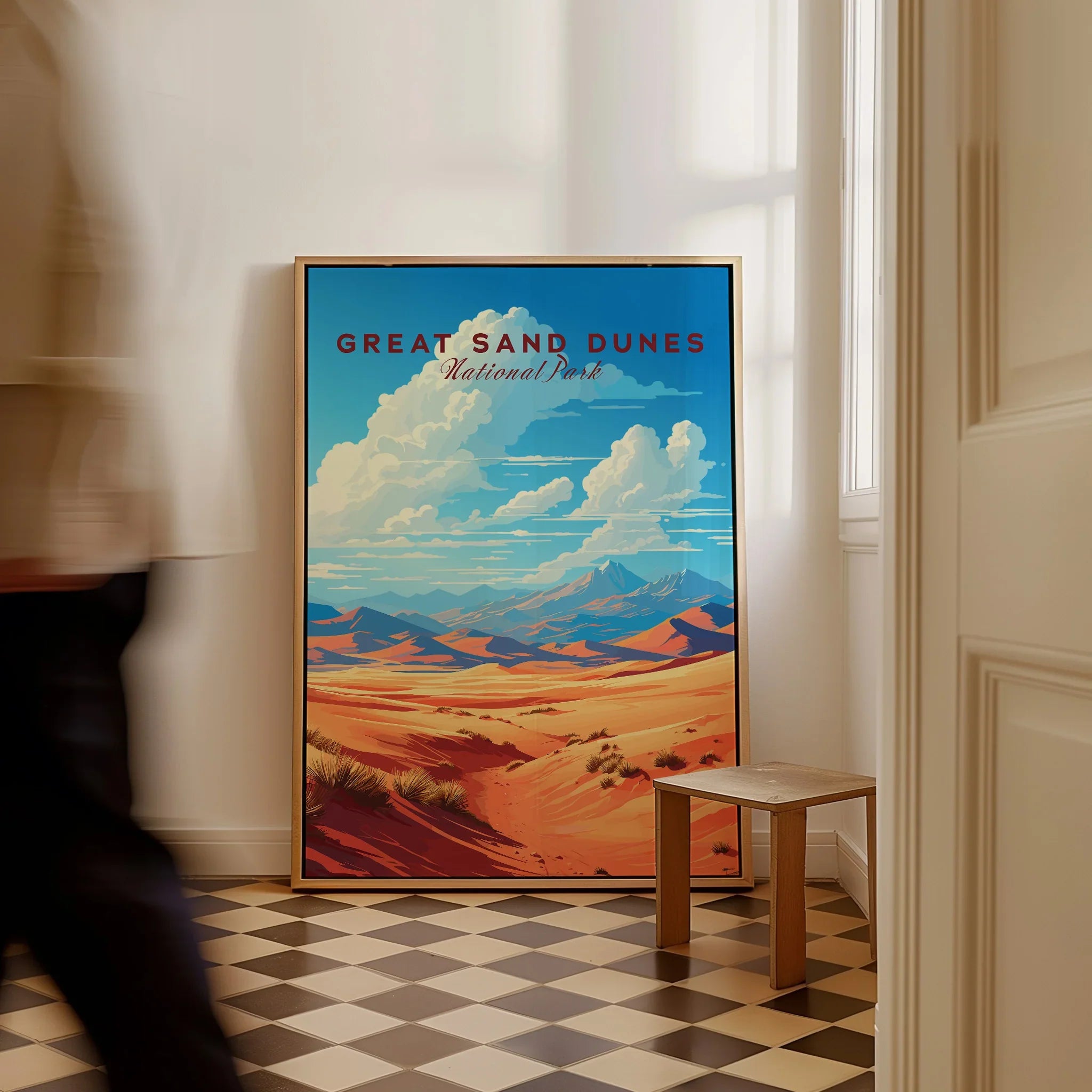 Framed Great Sand Dunes National Park travel poster leaning on wall in modern home interior.