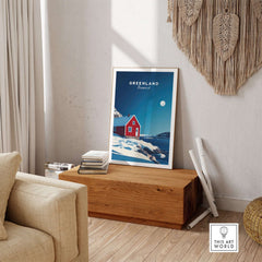 Greenland Travel Poster showcasing a vibrant landscape with a red house and icy scenery in a stylish living room setting.