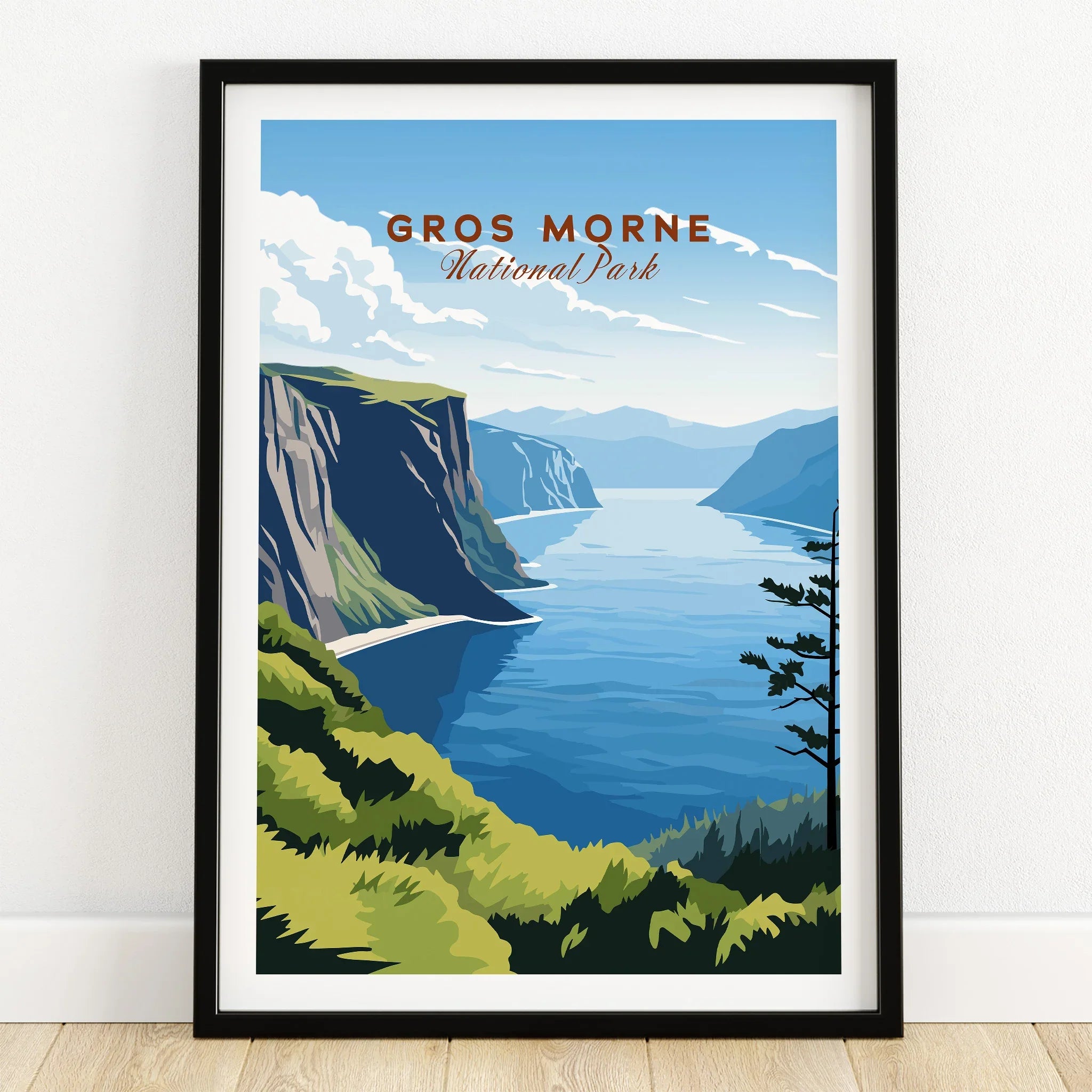 Gros Morne National Park art print in black frame, landscape with cliffs and water, on wooden floor